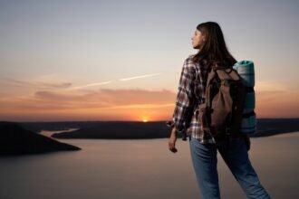 A solo woman traveller confidently exploring a scenic destination during her travel journey.
