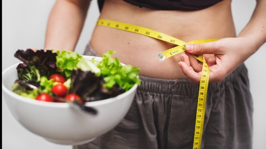 woman measuring her tummy for weight loss
