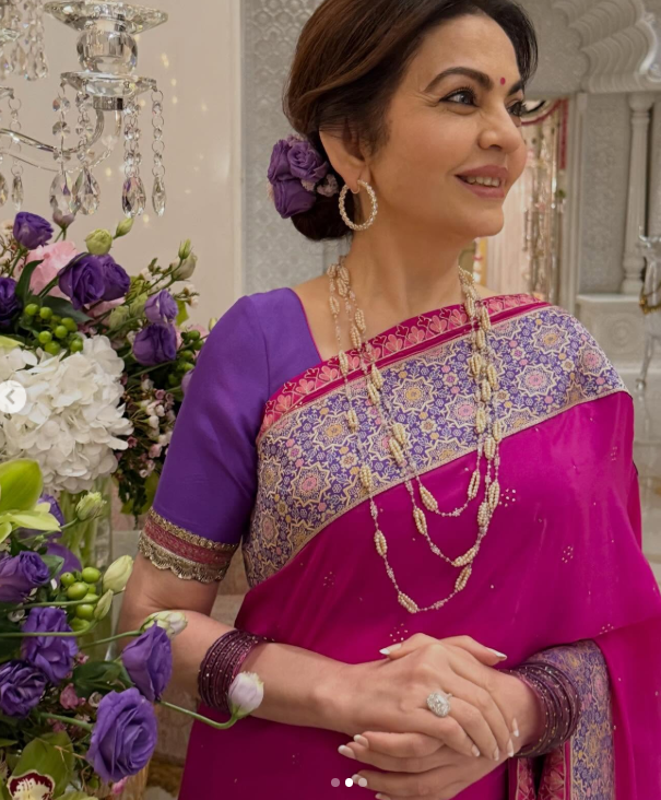 Nita Ambani is rani-pink saree and multi-layered pearl necklace. 